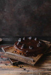 Chocolate cake with glaze on rustic wooden table