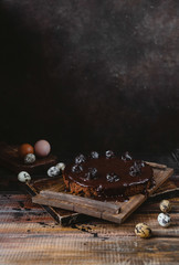 Chocolate cake and chicken and quail eggs on rustic wooden table