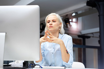 Praca w biurze.  Młoda kobieta pracuje przy komputerze.
