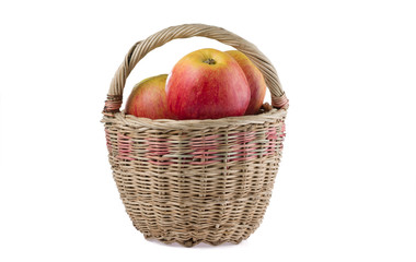 Wicker basket with ripe apples isolated on white background.