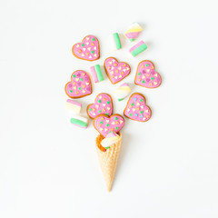 Food composition with gingerbread cookies and marshmallow in waffle cone on white background. Flat lay. top view.