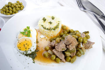Delicious dinner beef Stroganov with peas and sterilized cucumber