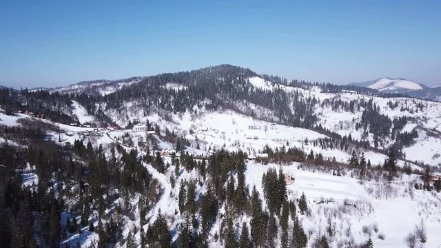 4k.Aerial. Winter time in mountains, rural area. Decrease in height