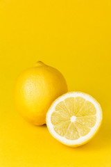 two lemons infront of a yellow background
