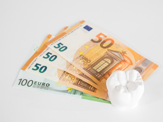 The model tooth szeht on the money in euro currency on the white background