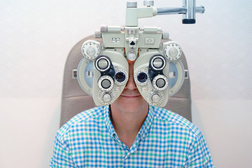 Man ophthalmologist examining patient man with optometrist trial frame. Male patient to check vision in ophthalmological clinic