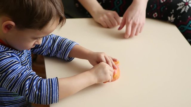 Children's creativity. The child and his mother mold figures from the dough on the table. Cute childish forms of plasticine on the table.
