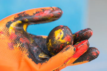Happy easter day concept : Yellow eggs in orange colored glove for family preparing painting egg in holiday, close-up. Easter is festival and holiday celebrating resurrection of Jesus from dead.