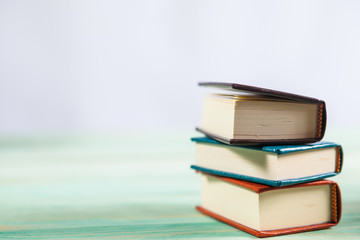 Pile of miniature books on wooden background. With copy space for your text