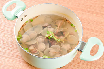 Clams soup cooked in a white pot in recipe