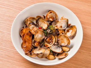 Stir-frying Ginger and clams at high heat to bring forth the savory aroma with sesame oil in recipe