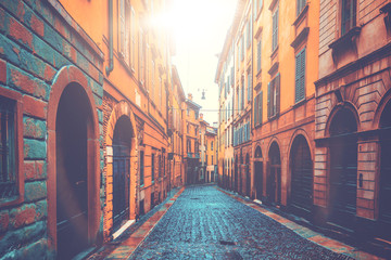 beautiful and ancient buildings in a street with warm sunlight in the middle