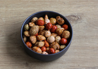 Bowl with Japanese cocktail nuts on wooden background