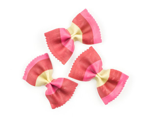 Farfalle pasta with red beet and paprika isolated on white background top view three raw classic traditional Italian.