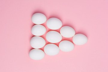 Happy Easter concept. White eggs on pink background close up. Flat lay. Minimal concept. Top view. Design, visual art.