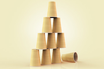 3D rendering of plastic cups stacked in a pyramid with one fallen down representing the concept of failure at teamwork.