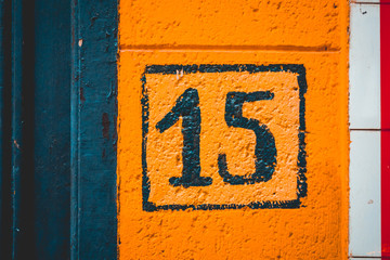orange painted number 15 door sign