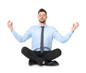 Young businessman meditating on white background