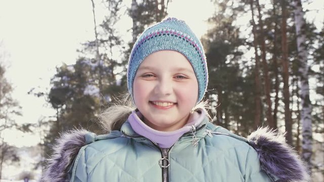 portrait of a smiling little girl in a winter forest