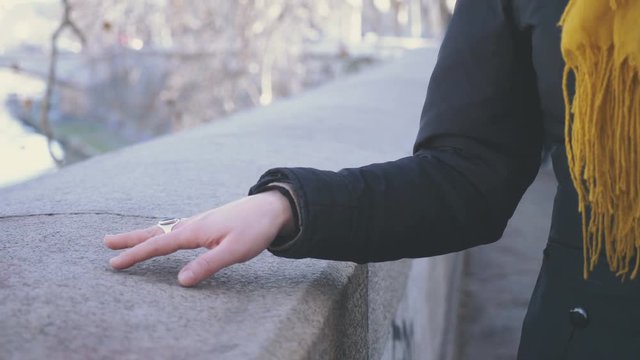 hands of a young woman walking playing on a wall