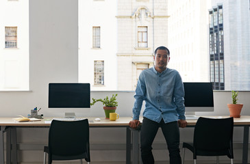 Young Asian designer standing alone in a modern office