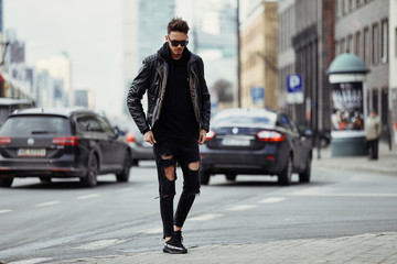 Model looking man stand on the city street with cars background, look on his watch and around