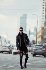 Model looking man stand on the city street with cars background, look on his watch and around