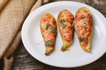 Baked stuffed zucchini with meat on a plate.