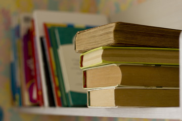 thick books on a wooden shelf