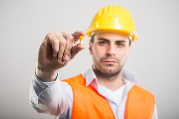 Selective focus of handsome architect holding one pill