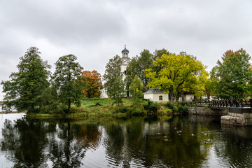 Fototapeta na wymiar Autumn view of a white church located by a river