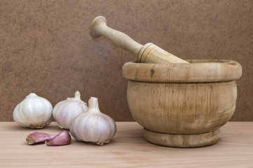 garlic and mortar for chopping on wooden table