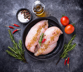 Raw chicken fillet in cast iron pan