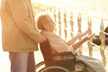 Senior woman in wheelchair with her friend from care home near river