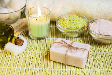 Spa setting with natural soap, olive oil, bath salts and candle. Wellnes concept.