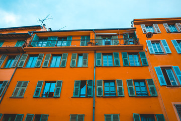 low angle view of orange house with green windows
