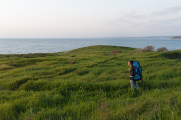 Young woman with backpack hiking in the open air