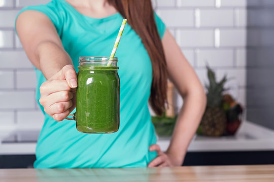 Woman holding a healthy green smoothie.