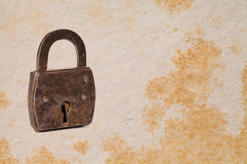 Vintage padlock on aged textured paper background. copy space