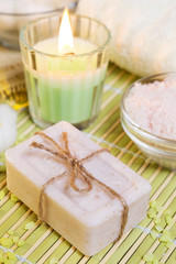 Obraz na płótnie Canvas Spa setting with natural soap, bath salts and candle. Wellness concept.