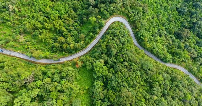 Aerial view of road on mountains and forest with truck driving up hill. Beautiful nature and transportation from panoramic view.