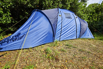 Blue camping tent in lush foliage