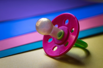 Baby pacifier on colored paper