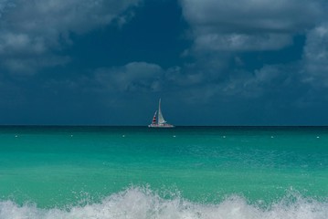 Fototapeta premium white beach with with sailboats in the ocean in the Caribbean sea Island of Aruba