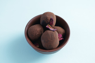 Homemade delicious  and intense dark chocolate truffles in adorable clay bowl.