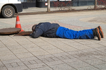 Man is working next to a manhole cover