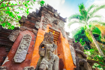 Majestic and tall rock statues Barong Lion Guard near shrine walls lit by sunshine at sunny day, Gunung Kawi Temple Complex, Bali, Indonesia. Balinese mythological creature, made of volcanic rock