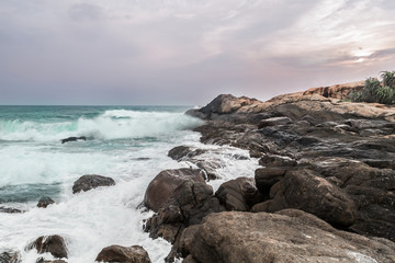Fototapeta na wymiar Abendstimmung am Stand mit Felsen und Steinen von Arugam Bay, Sri Lanka