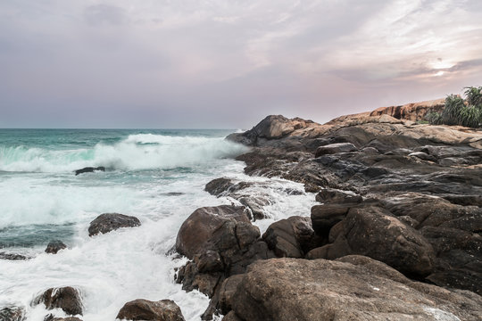 Abendstimmung am Stand mit Felsen und Steinen von Arugam Bay, Sri Lanka