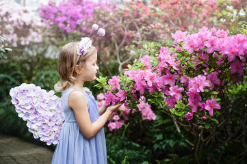 Fototapeta premium girl sniffing flowers of azaleas. flowering azaleas in the park